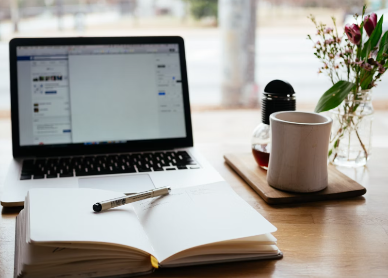Image of laptop and opened book | How to Find and Connect With Your Ideal Clients
