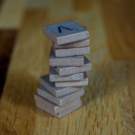 Image of stacked metal pieces on wood | The Minimal Marketing Stack for Coaches