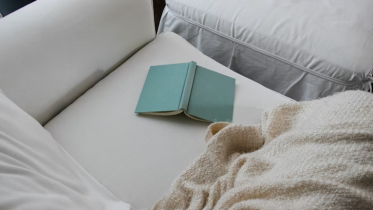 Image of a green book on couch | Why Doing Less Marketing Can Actually Create More Impact